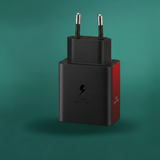 Black and red power adapter on a green background
