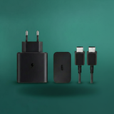 Set of black electronic accessories including a charger, cable, and adapter on a green background