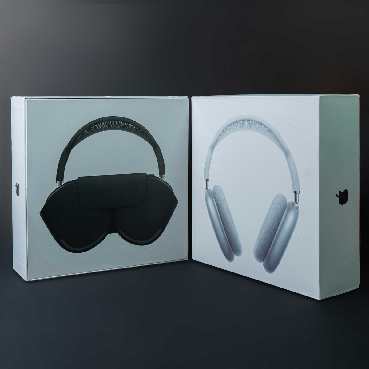 Two boxes containing a black sleep mask and gray headphones on a dark background