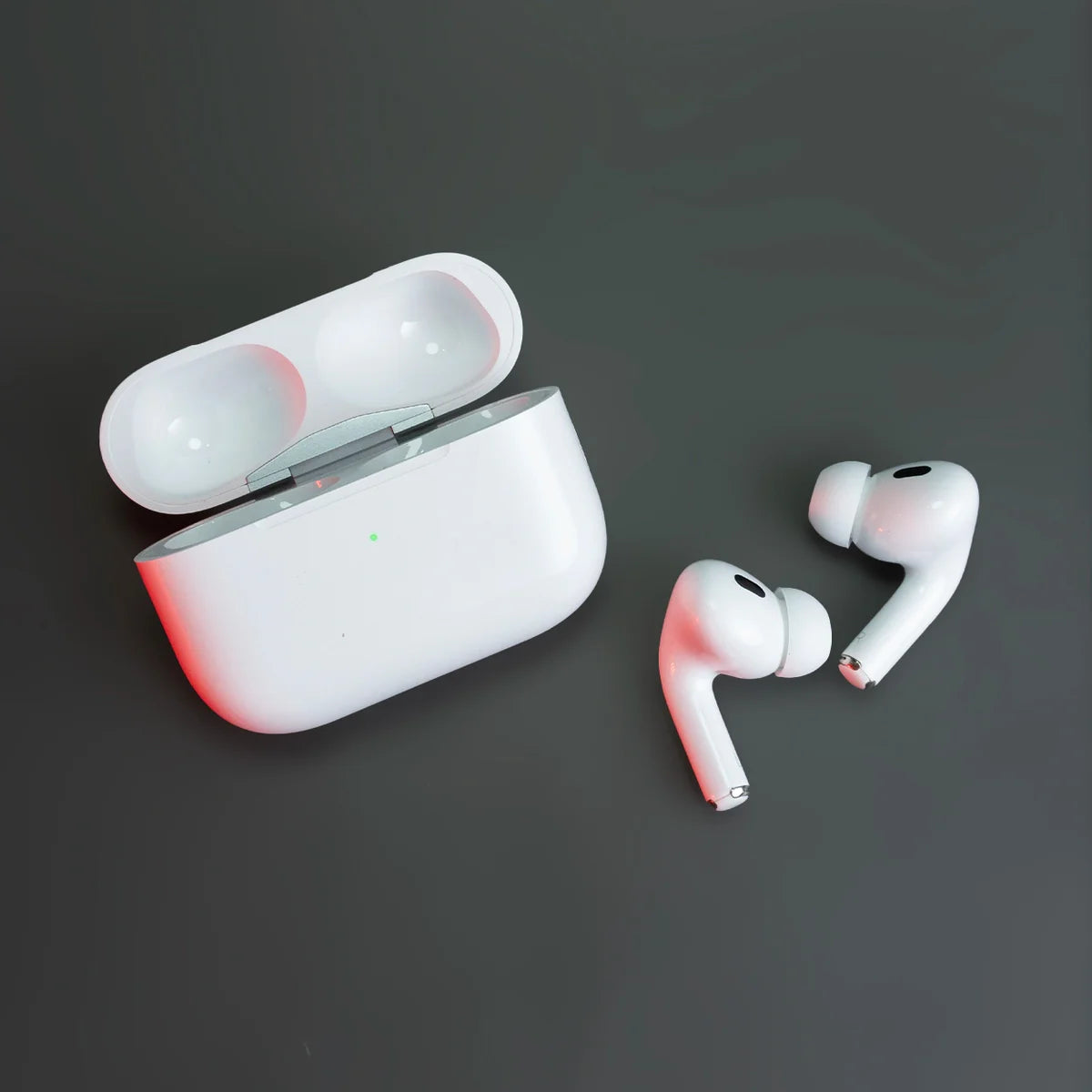 White wireless earbuds with charging case on a dark background